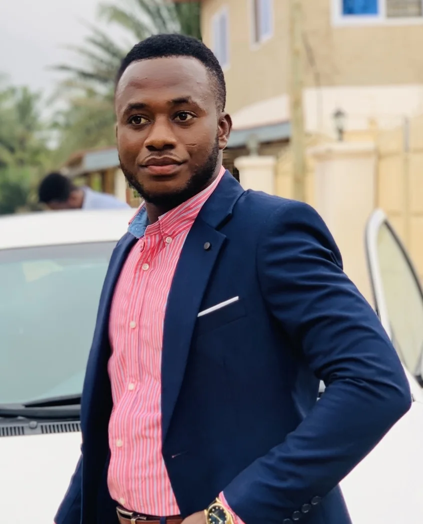 Dacosta Agyei in a navy blazer and pink shirt.